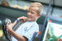 Dreng med lange om halsen i Darwins Hus i Odense ZOO